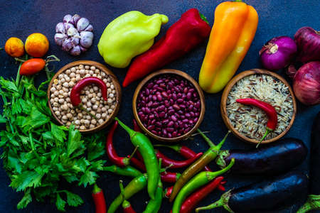 Organic food concept with variety of fresh vegetables and cereals on stone background with copy...
