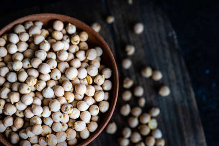 Bowl full of chickpeas on dark background with copy space