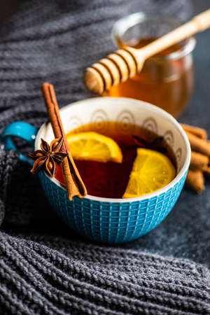 Mulled tea with lemon and spices on stone table with copy space