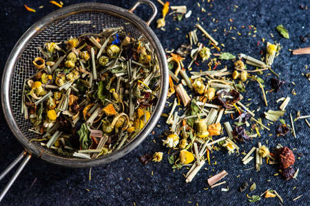 Floral tea concept with tea pot and cups on stone background with copy space