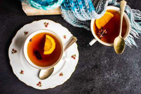 Mulled tea with lemon and spices on stone table with copy space