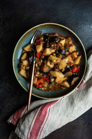 Popular georgian summer and autumnal dish Ajapsandali with vegetables on stone background with copy...