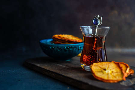 Turkish tea concept with dried persimmons on dark background with copy space