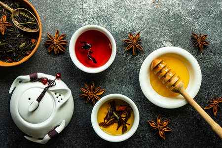 Floral tea concept with tea pot and cups on stone background with copy spaceの写真素材
