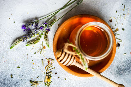 Floral honey concept with glass of honey and dried flowersの写真素材