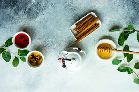 Floral tea concept with tea pot and cups on stone background with copy space