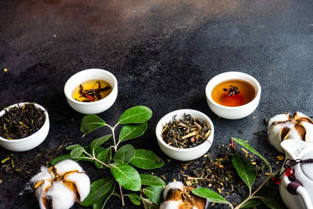 Floral tea concept with tea pot and cups on stone background with copy spaceの写真素材