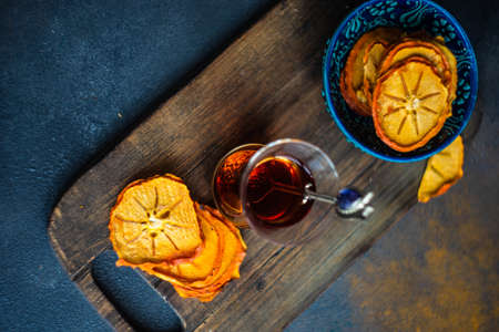 Turkish tea concept with dried persimmons on dark background with copy space