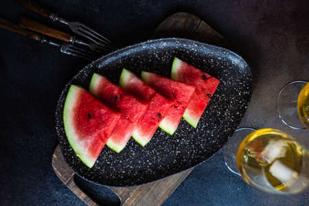 Organic watermelon slice on a plate served on stone background with copy spaceの写真素材