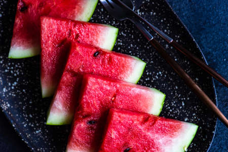 Organic watermelon slice on a plate served on stone background with copy spaceの写真素材