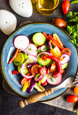 Healthy food concept with fresh organic vegetables salad on stone background with copy spaceの写真素材