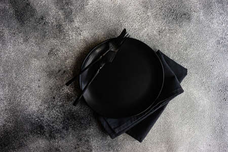 Cutlery set with empty plates on stone background with copy spaceの写真素材