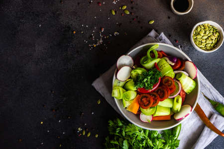 Healthy food concept with fresh organic vegetables salad on stone background with copy spaceの写真素材