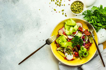 Healthy food concept with fresh organic vegetables salad on stone background with copy spaceの写真素材