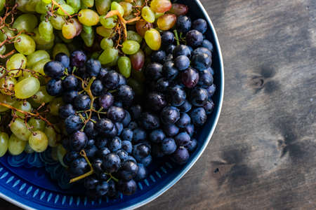 Organic food concept with variety of ripe grape on stone background with copy spaceの写真素材