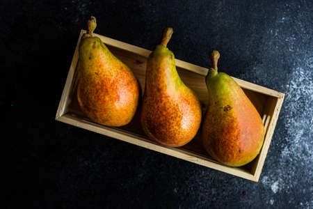 Organic food concept with ripe summer pears on dark stone background with copy spaceの写真素材