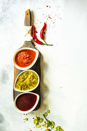 Variety of traditional georgian satsebeli sauces with kiwi, tomato and blackberry  on stone background with copy spaceの写真素材