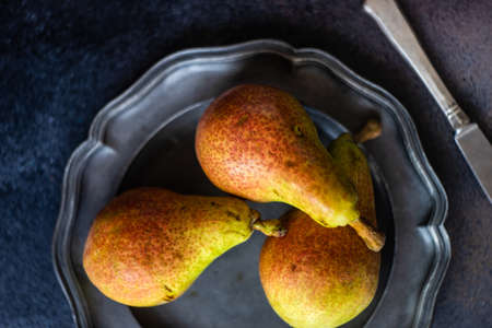 Organic food concept with ripe summer pears on dark stone background with copy spaceの写真素材