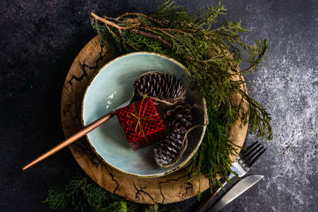Holiday table seting with xmas tree and cutlery on stone background with copy space