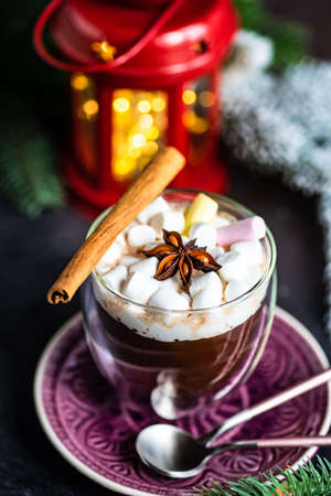 Glass with christmas cocoa drink with marshmallow on stone background with copy space
