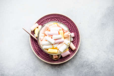 Glass with christmas cocoa drink with marshmallow on stone background with copy spaceの写真素材