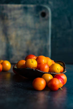 Organic georgian plums (tkemali) on stone background with copy space