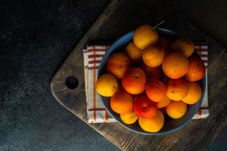 Organic georgian plums (tkemali) on stone background with copy space