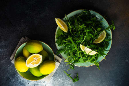 Healthy vegetable salad with organic rocket herb, lemon and flax seeds on stone background