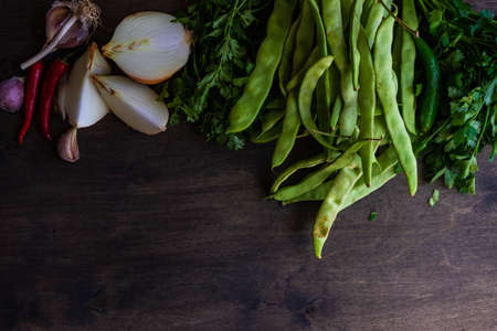 Ingredient for georgian lobio with onion, french lobio, coriander on wooden background with copy spaceの写真素材