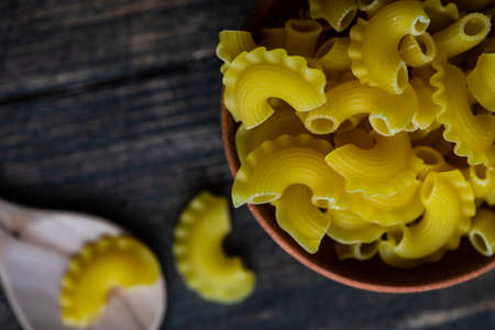Cooking concept with Creste di Gallo pasta in a bowl on rustic table with copy spaceの写真素材