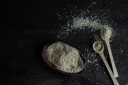 Healthy food concept with oats bran in a bowl with wooden spoon on dark rustic background with copyspaceの写真素材