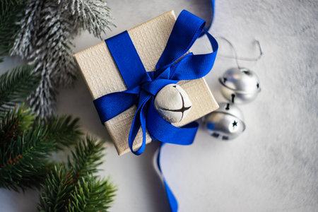 Christmas frame with gift box, holiday decor and fir tree on white stone background with copy spaceの写真素材