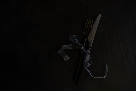 Christmas table setting with stylish black cutlery set with simple holiday decor on stone background with copy spaceの写真素材