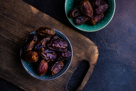 Oganic date fruits in a bowl on rustic background with copy spaceの写真素材