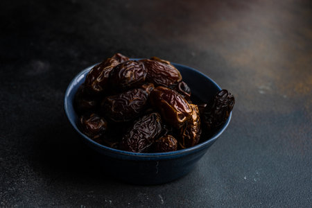 Oganic date fruits in a bowl on rustic background with copy spaceの写真素材