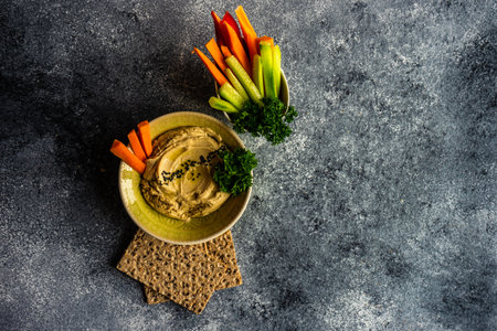 Traditional chickpeas hummus with olive oil and sesame seeds on stone background with copy spaceの写真素材
