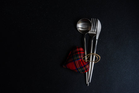 Cutlery set for festive dinner for St. Valentines Day on dark background with copy spaceの写真素材