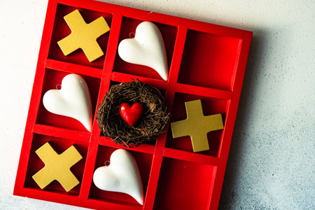St. Valentine card concept with tic-tac-toe board game and hearts on stone white background with copy spaceの写真素材