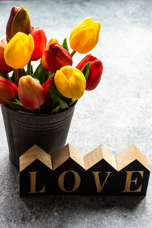 St. Valentine card concept with tulips, hearts and gift on stone background with copy spaceの写真素材