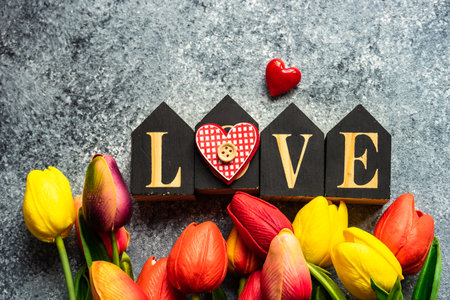 St. Valentine card concept with tulips, hearts and gift on stone background with copy spaceの写真素材