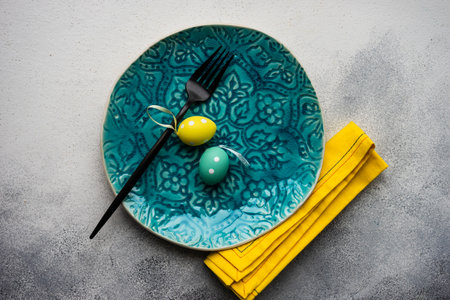 Table setting with eggs for festive holiday Easter dinner on rustic background with copy spaceの写真素材