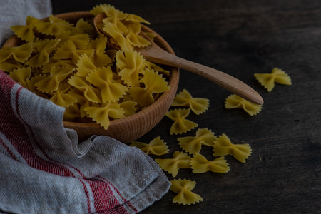 farfalle pasta in a bowl on rustic background with copy space