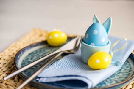 Holiday table setting for festive Easter dinner decorated with eggs