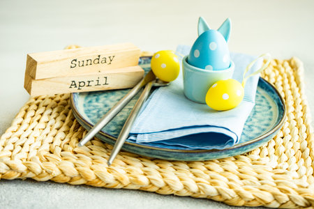 Holiday table setting for festive Easter dinner decorated with eggs