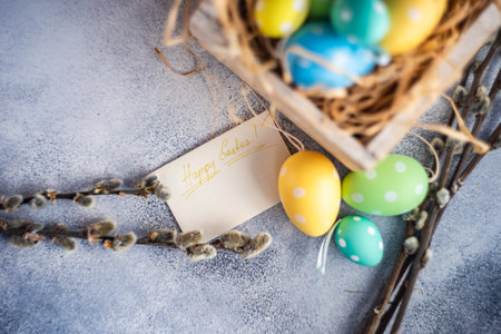 Easter holiday card concept with colored eggs in nest on concrete background with copy spaceの写真素材