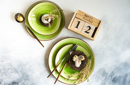 Festive table setting for holiday Easter dinner decorated with eggs and heather flowers on stone...