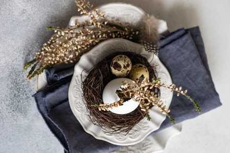 Festive table setting for holiday Easter dinner decorated with eggs and heather flowers on stone...