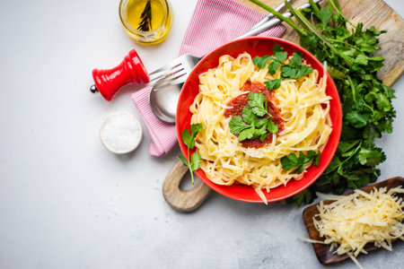 Homemade Fettuccine pasta with cheese and tomato sauce  on stone rustic background with copy spaceの写真素材