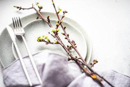 Spring table setting with cutlery and blooming cherry branch on rustic background with copy spaceの写真素材