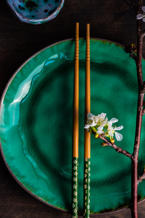 Asian style table setting with cherry blossom and wooden chopsticksの写真素材